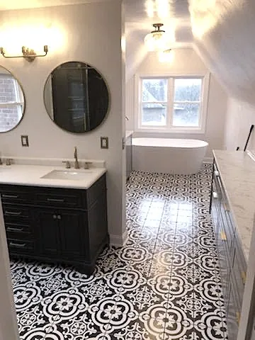 Bathroom remodel with patterned tile floor, freestanding tub and dark vanity