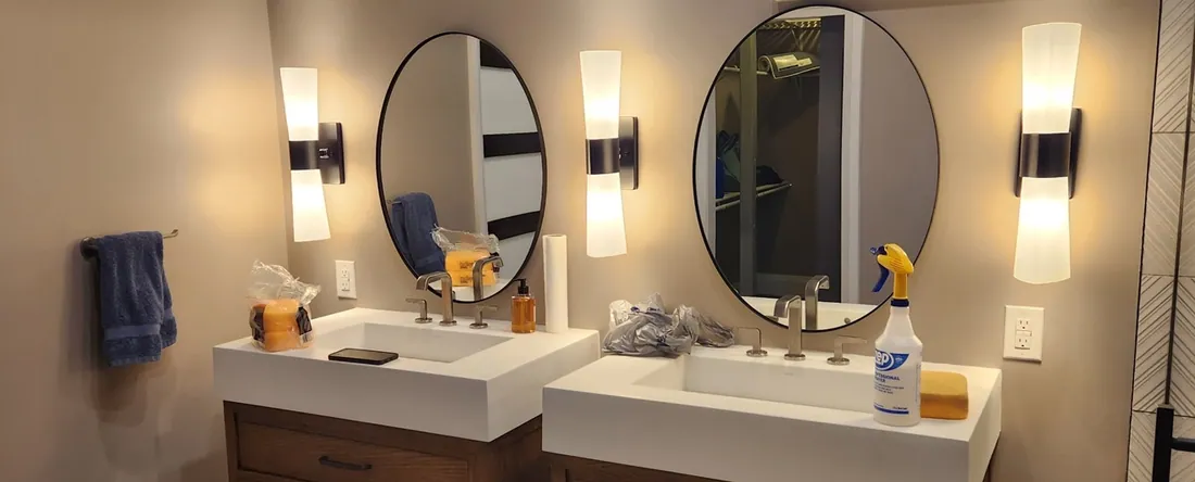 Double vanity bathroom remodel with round mirrors and new lighting